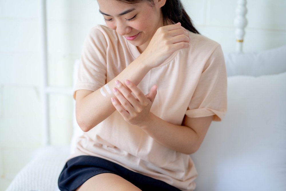 woman moisturizing arm