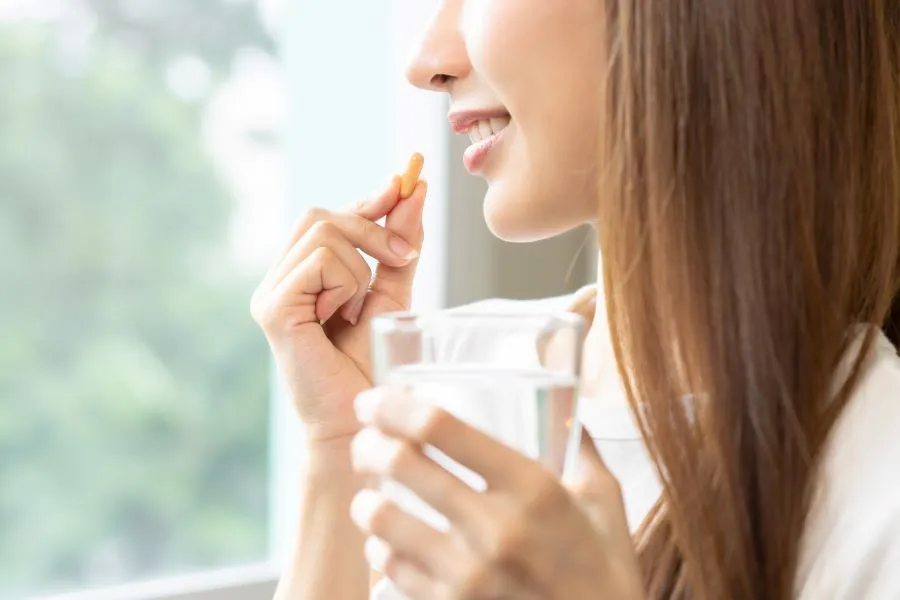 woman taking vitamins for hair
