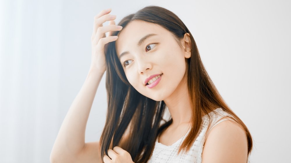a young woman combing her hair with her fingers