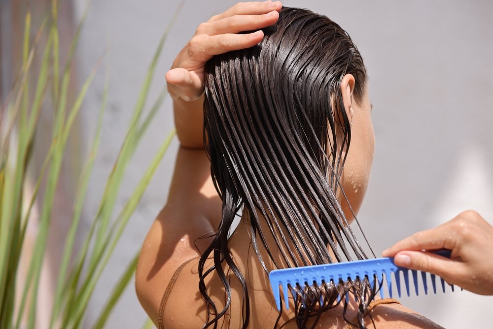 woman combing her wet hair