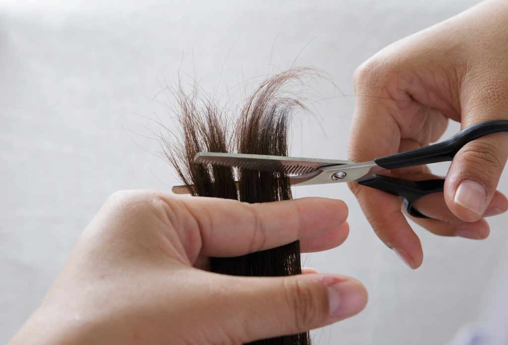 a woman trimming her hair