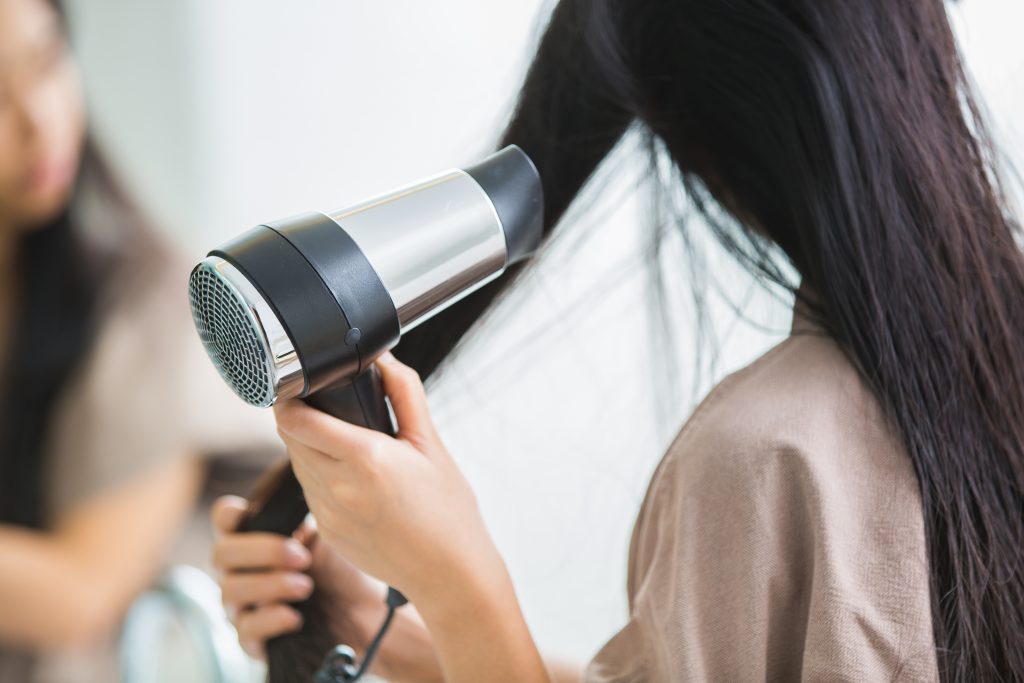a woman blow drying her hair