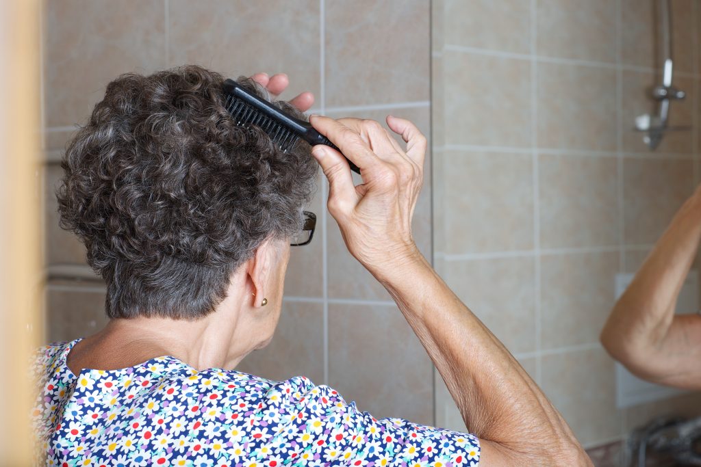 old woman brushing her hair